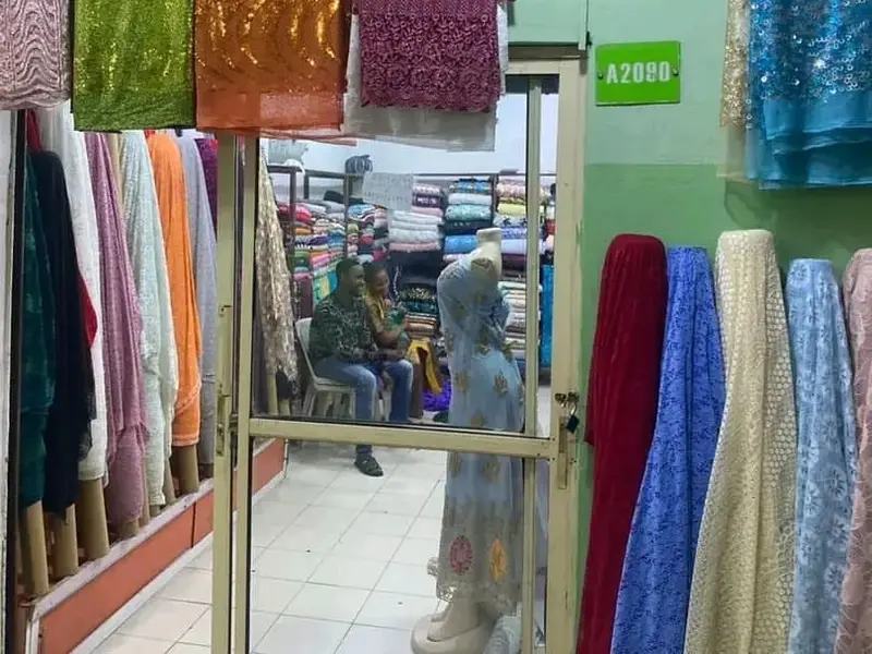 Sequin and lace fabrics hanging at fabric shop A2080 in Tejuosho Market, Yaba